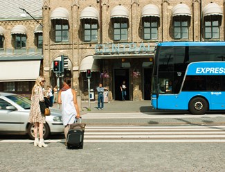 Flera personer som står och väntar vid övergångsställe framför Centralstationen