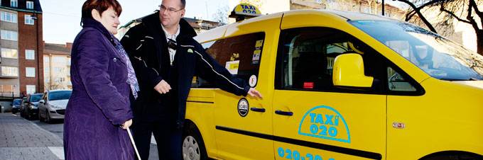 Kvinna som får hjälp in i en taxibil